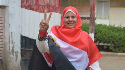صور| فنان تشكيلي وابنته مرتدية علم مصر يصوتان في انتخابات الرئاسة بقرية شطورة