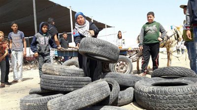 صور| سيدة فلسطينية تجمع إطارات السيارات لصالح المنتفضين بمسيرات العودة