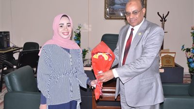 طالبة تقدم باقة ورود لرئيس جامعة الوادي الجديد بعد فوز كليتها بالأفضل