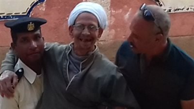 أمين شرطة يحمل مريض للإدلاء بصوته على التعديلات الدستورية فى سوهاج